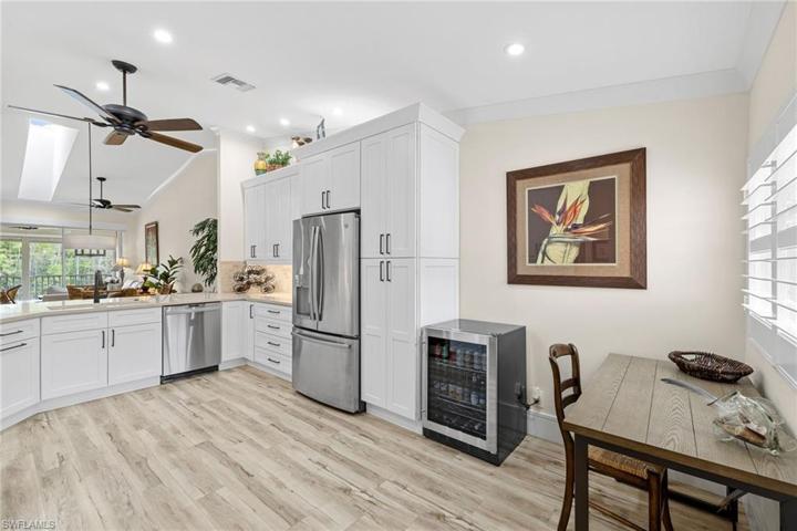 View facing refrigerator, wine cooler, and small desk