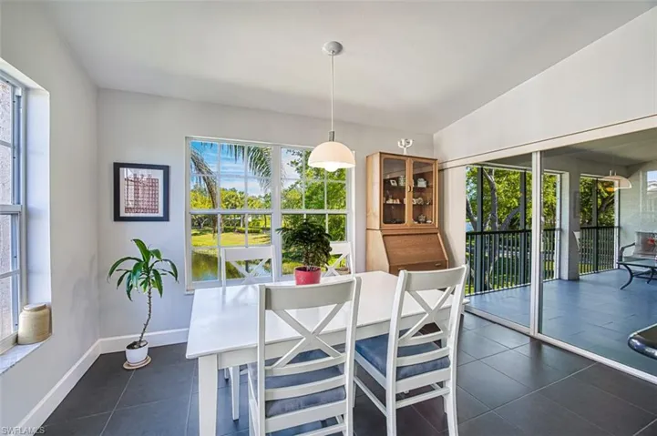 Dining space featuring vaulted ceiling, dark tile patterned flooring, and baseboards