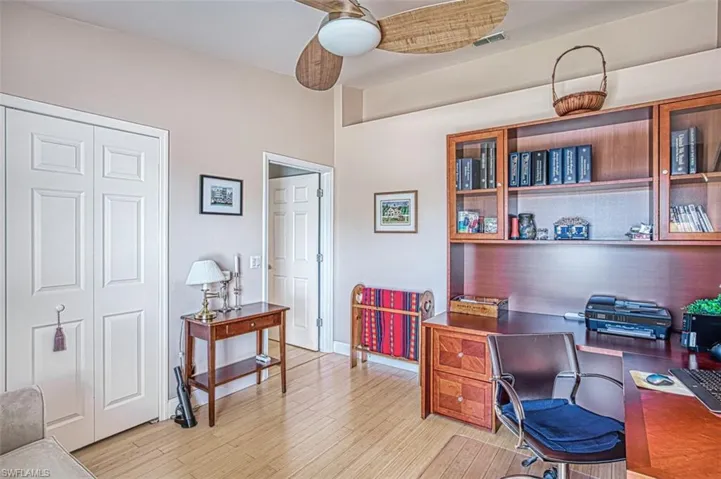 Office space with light wood-style floors, visible vents, and baseboards
