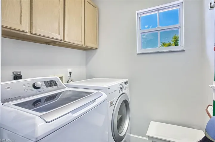 Laundry room with washer and clothes dryer and cabinet space
