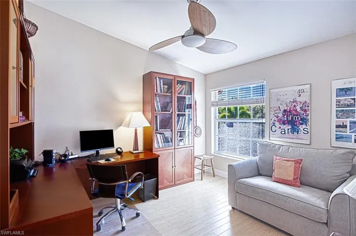 Office with baseboards, lofted ceiling, ceiling fan, and light wood finished floors
