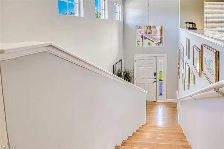 Staircase featuring a high ceiling and wood finished floors