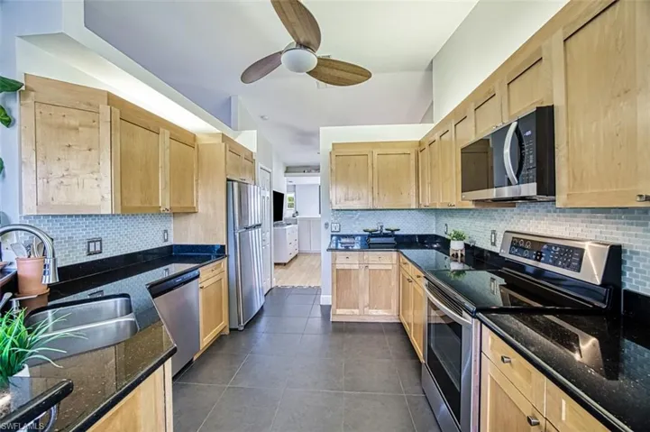 Kitchen with a sink, stainless steel appliances, backsplash, and light brown cabinetry