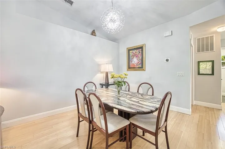 Dining room with visible vents, light wood-style flooring, and baseboards