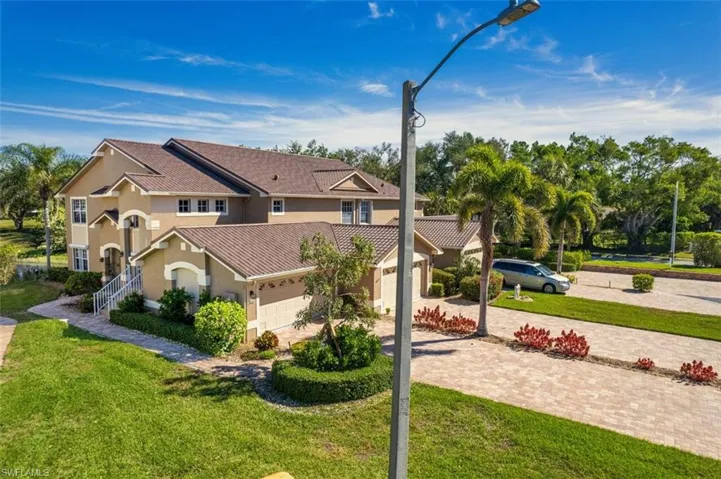View of front facade featuring a front yard, decorative driveway, an attached garage, and stucco siding
