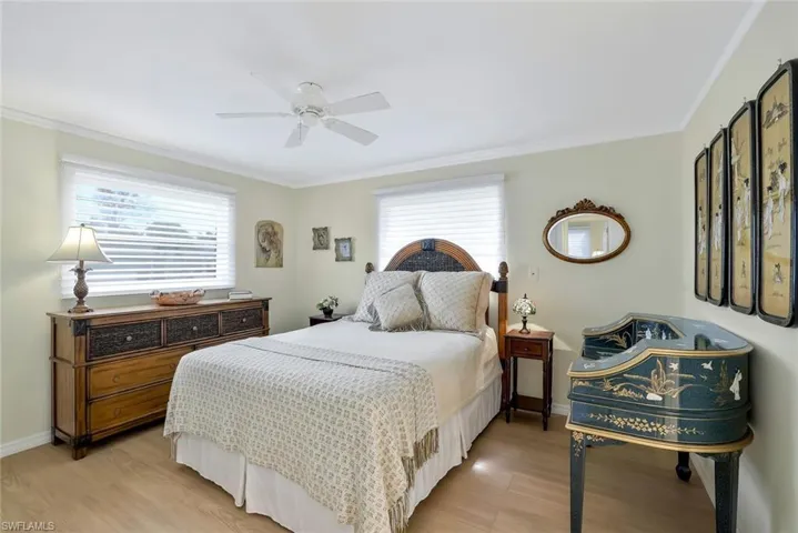 Bedroom featuring crown molding, ceiling fan, and light wood-type flooring