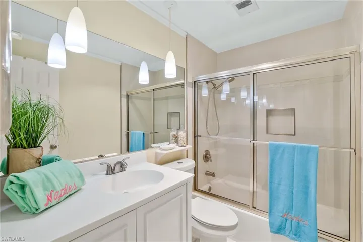 Full bathroom featuring vanity, bath / shower combo with glass door