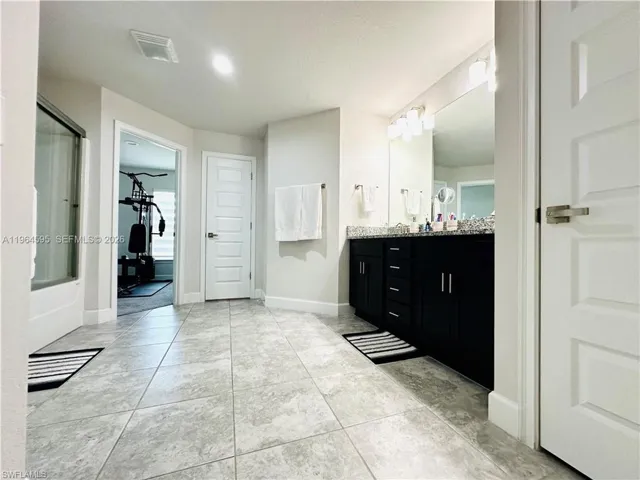 Full bath with vanity and light tile patterned flooring