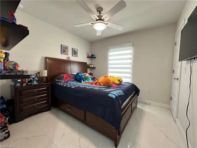 Bedroom with light marble finish flooring and a ceiling fan