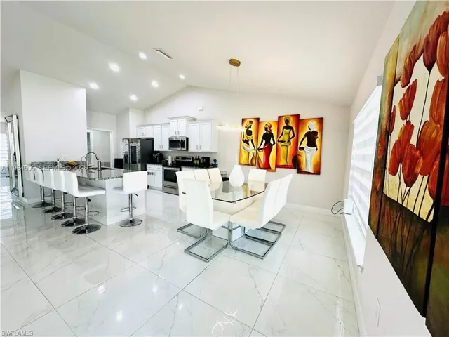 Dining area with lofted ceiling and recessed lighting