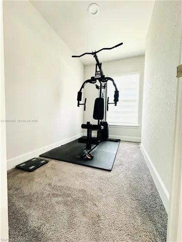 Workout room with carpet floors and baseboards