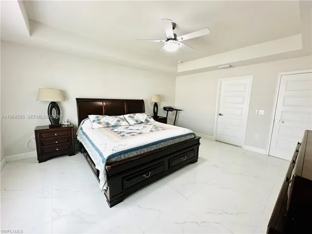 Bedroom with a tray ceiling and ceiling fan