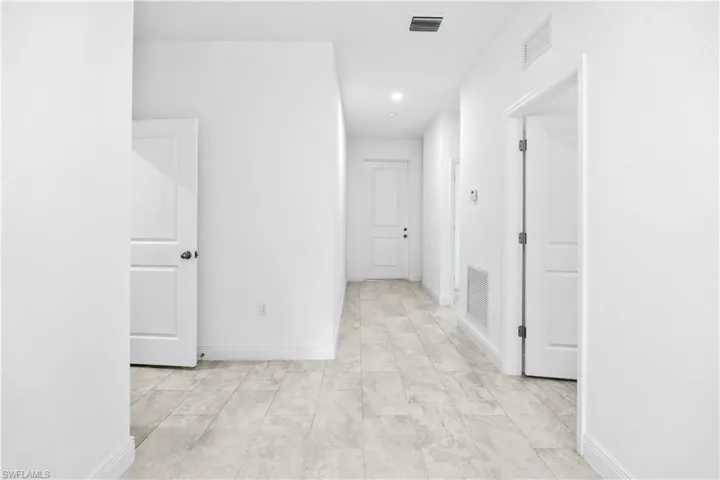 Hall with baseboards and recessed lighting