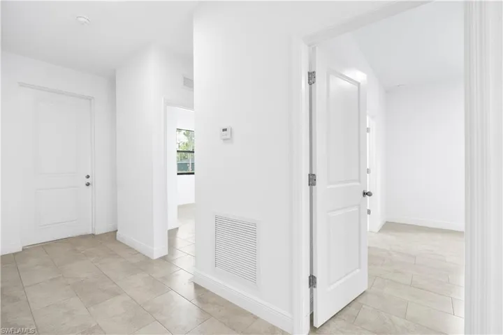 Hallway featuring baseboards and light tile patterned flooring