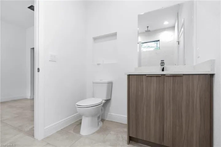 Full bath featuring vanity and a marble finish shower
