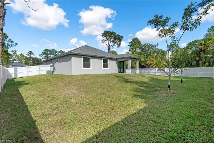 Back of property with stucco siding, a fenced backyard, and a patio