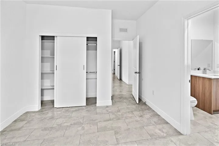 Unfurnished bedroom with a closet and connected bathroom