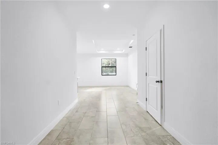 Hall featuring recessed lighting and a tray ceiling