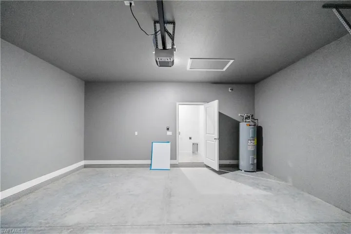 Garage featuring water heater and a garage door opener