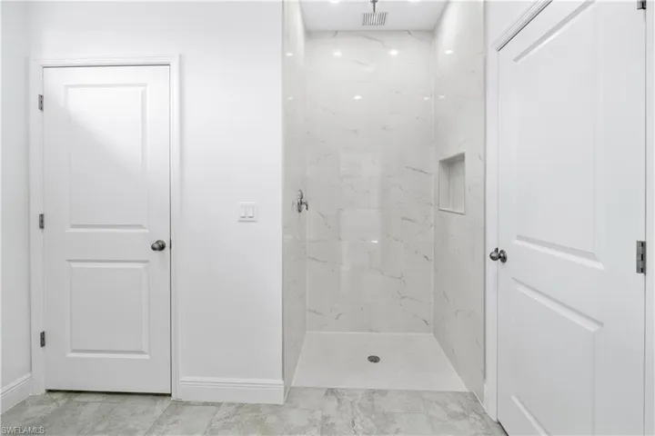 Bathroom featuring a marble finish shower