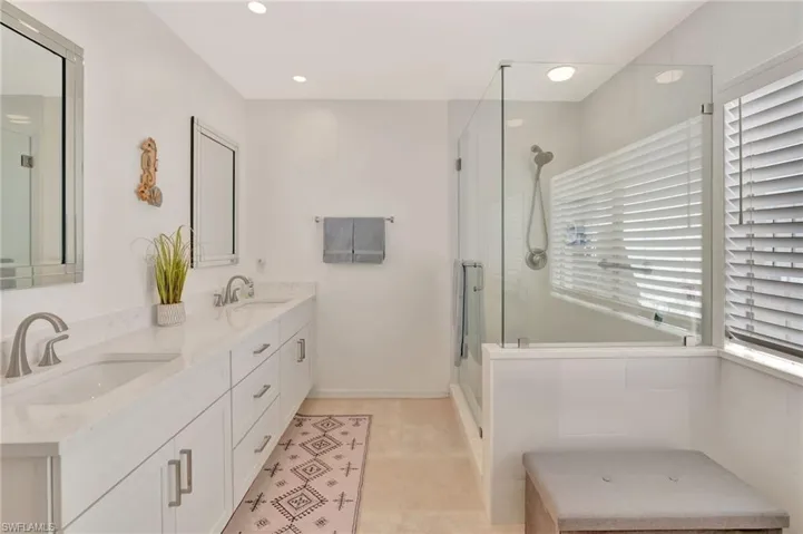 Bathroom with double vanity, a stall shower, tile patterned floors, and recessed lighting