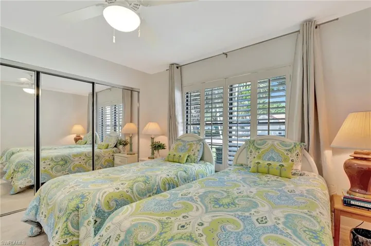 Bedroom with multiple windows, a closet, and a ceiling fan