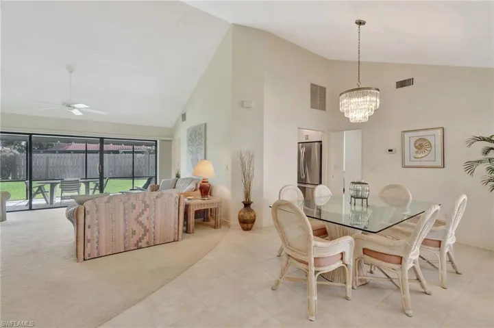Dining area featuring high vaulted ceiling, a chandelier, ceiling fan, and light tile patterned floors