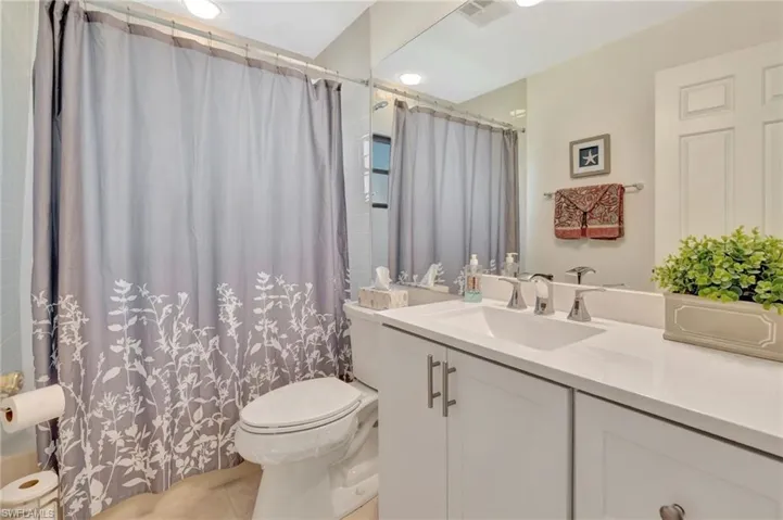 Full bathroom featuring vanity, tile patterned floors, and a shower with shower curtain