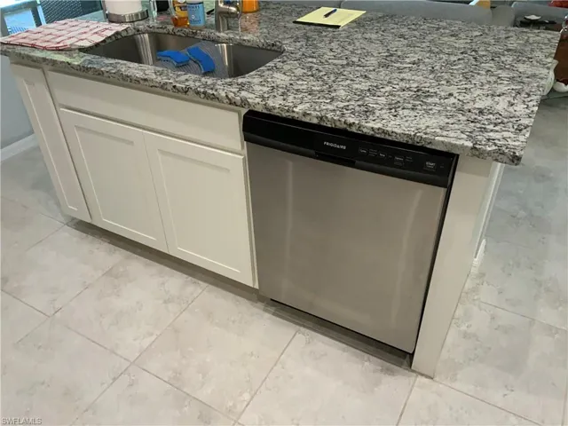 Kitchen Featuring Granite Counter and Dishwasher
