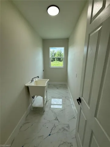 Bathroom featuring baseboards and marble look tile flooring