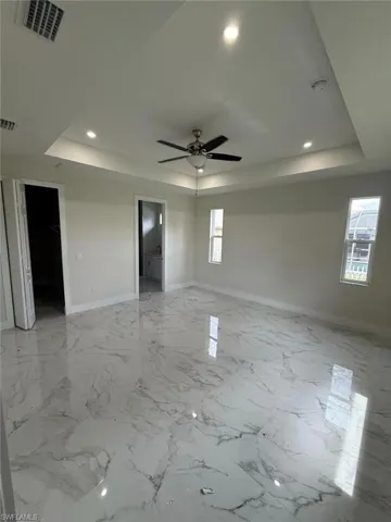 Unfurnished room featuring a tray ceiling, a ceiling fan, and recessed lighting