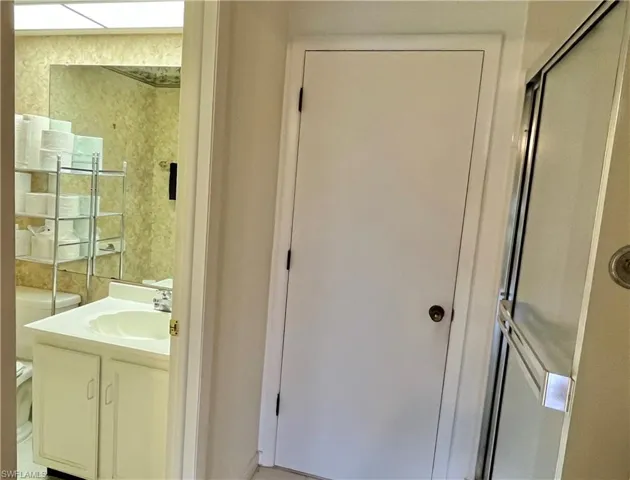 Bathroom featuring walk in shower, vanity, and toilet
