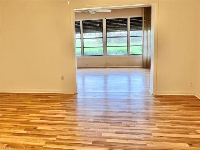 Empty room with ceiling fan and light hardwood / wood-style floors