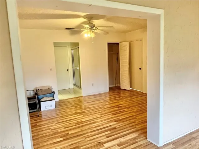 Unfurnished room featuring ceiling fan, a textured ceiling, and light hardwood / wood-style flooring