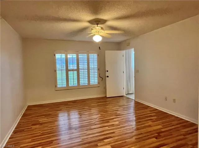 Unfurnished room featuring hardwood / wood-style floors, a textured ceiling, and ceiling fan