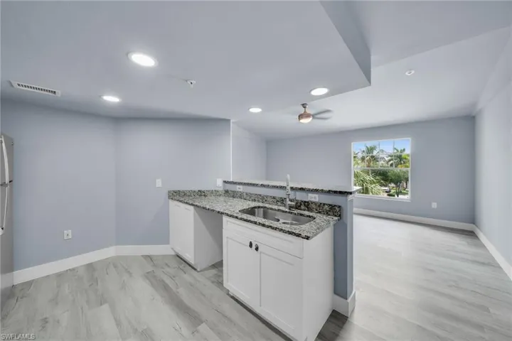 Open-concept living space featuring wood-finish flooring, recessed lighting, and a neutral color palette