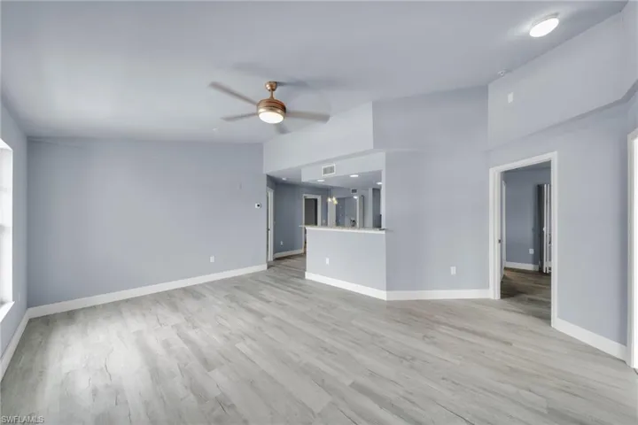 Spacious room featuring light wood-finish flooring, a ceiling fan, and recessed lighting