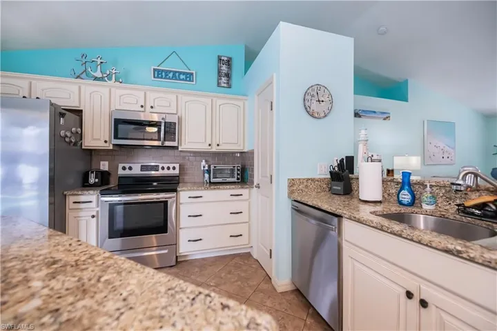 Kitchen with decorative backsplash, bright white cabinets and pantry