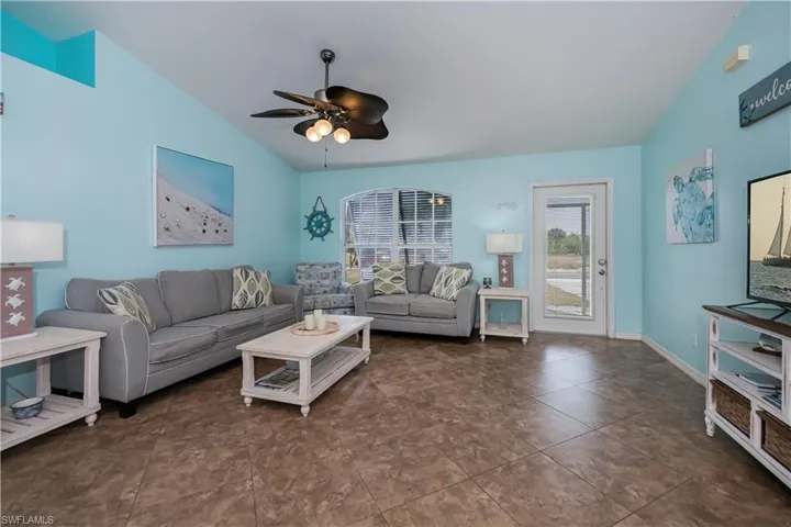 Sunny living room with a tropical vibe, coastal-inspired paint and a stylish ceiling fan
