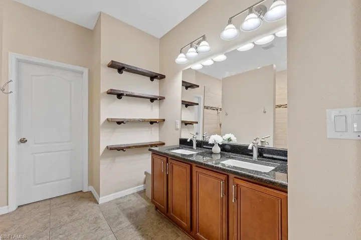 Bathroom featuring tile flooring and dual bowl vanity