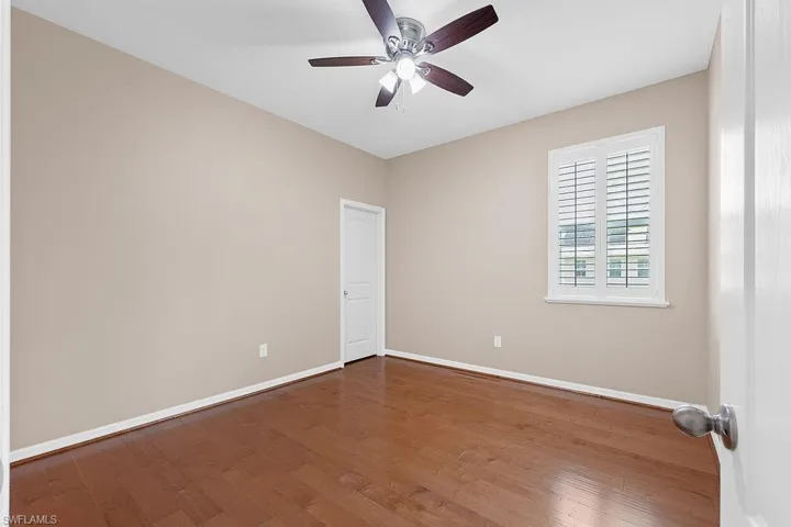 Unfurnished room with ceiling fan and dark wood-type flooring