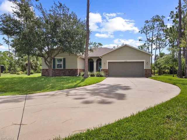 Ranch-style home featuring a garage and long front driveway