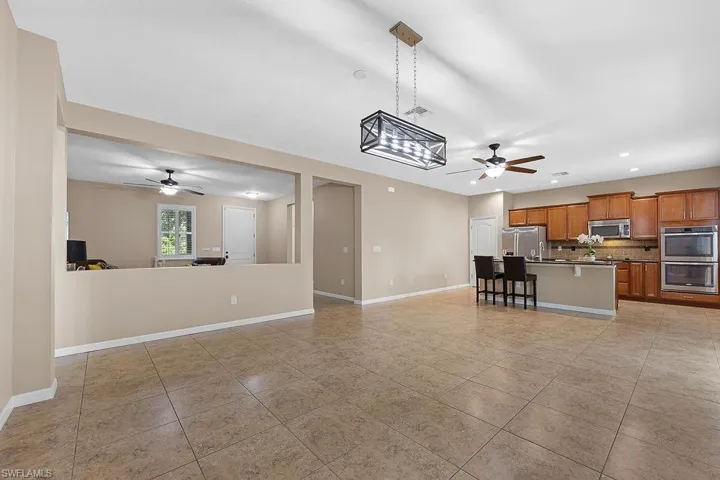 Unfurnished living room with ceiling fan and light tile floors