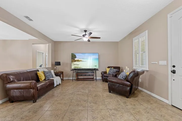 Living room with ceiling fan and tile flooring
