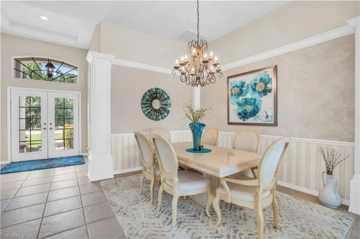 Tiled dining space featuring a chandelier, french doors, and a wealth of natural light