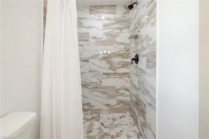 Bathroom with a stall shower and toilet