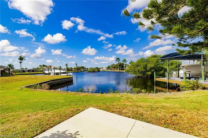 Dock with a water view and a lawn