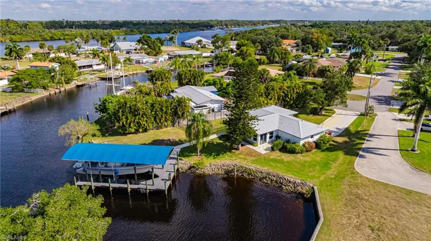 Aerial view of residential area featuring a large body of water and a tree filled landscape