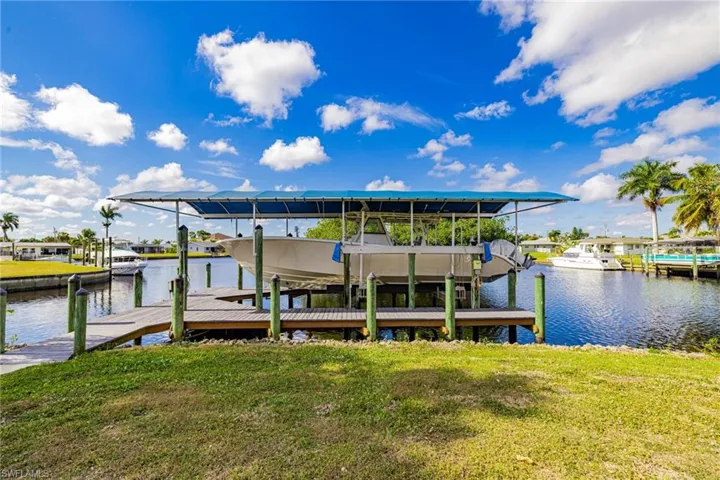 Dock area featuring a yard, boat lift, and a water view