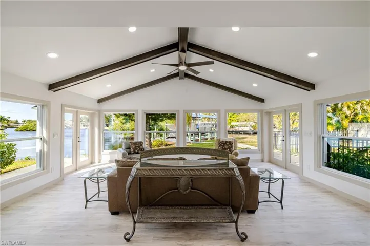 Sunroom featuring french doors, wood finished floors, recessed lighting, and a water view